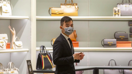 Sign of the times: Masked employee in a luxury store